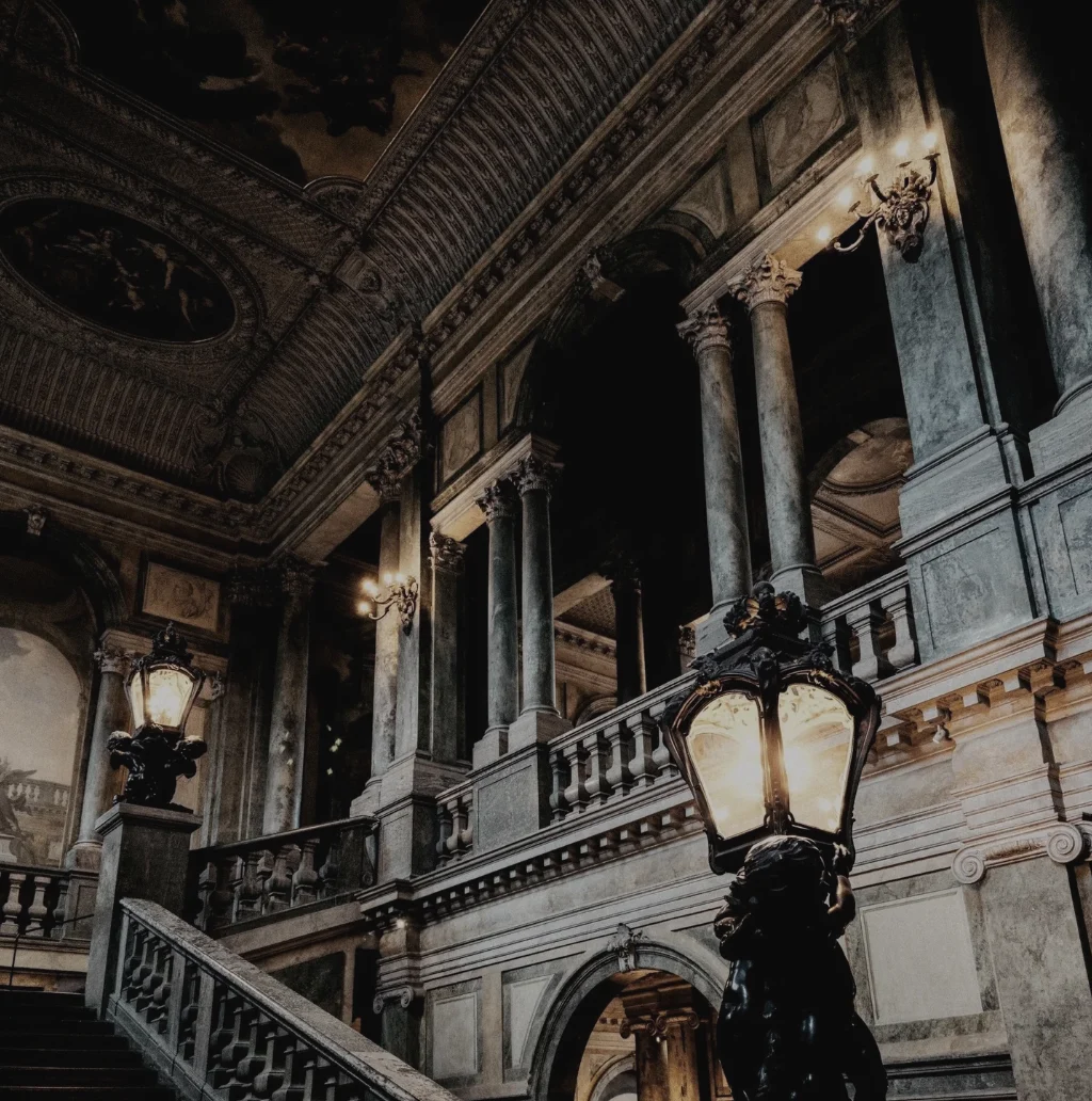 A grand marble staircase lit by ornate lanterns